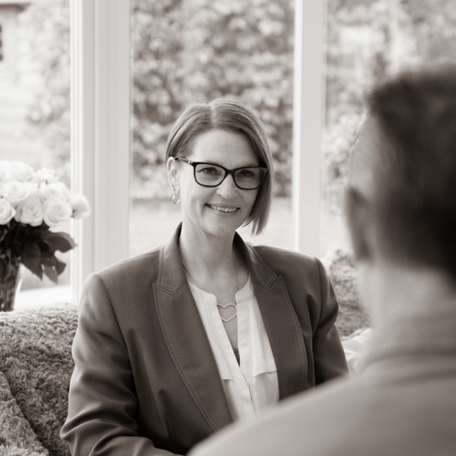 1:1 face to face executive coaching session, 2 people sat on a sofa